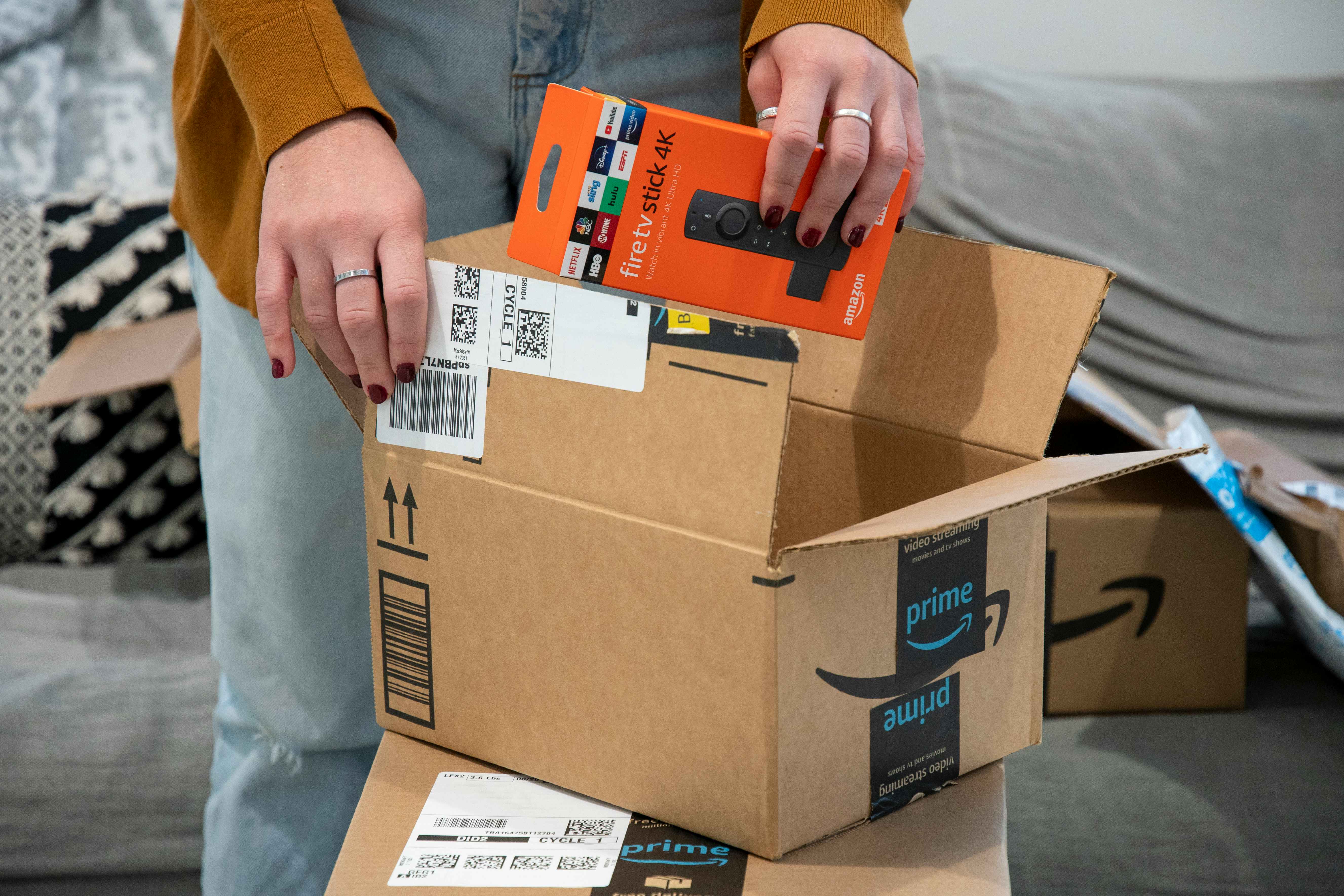 a person opening an amazon box and taking out a fire stick 