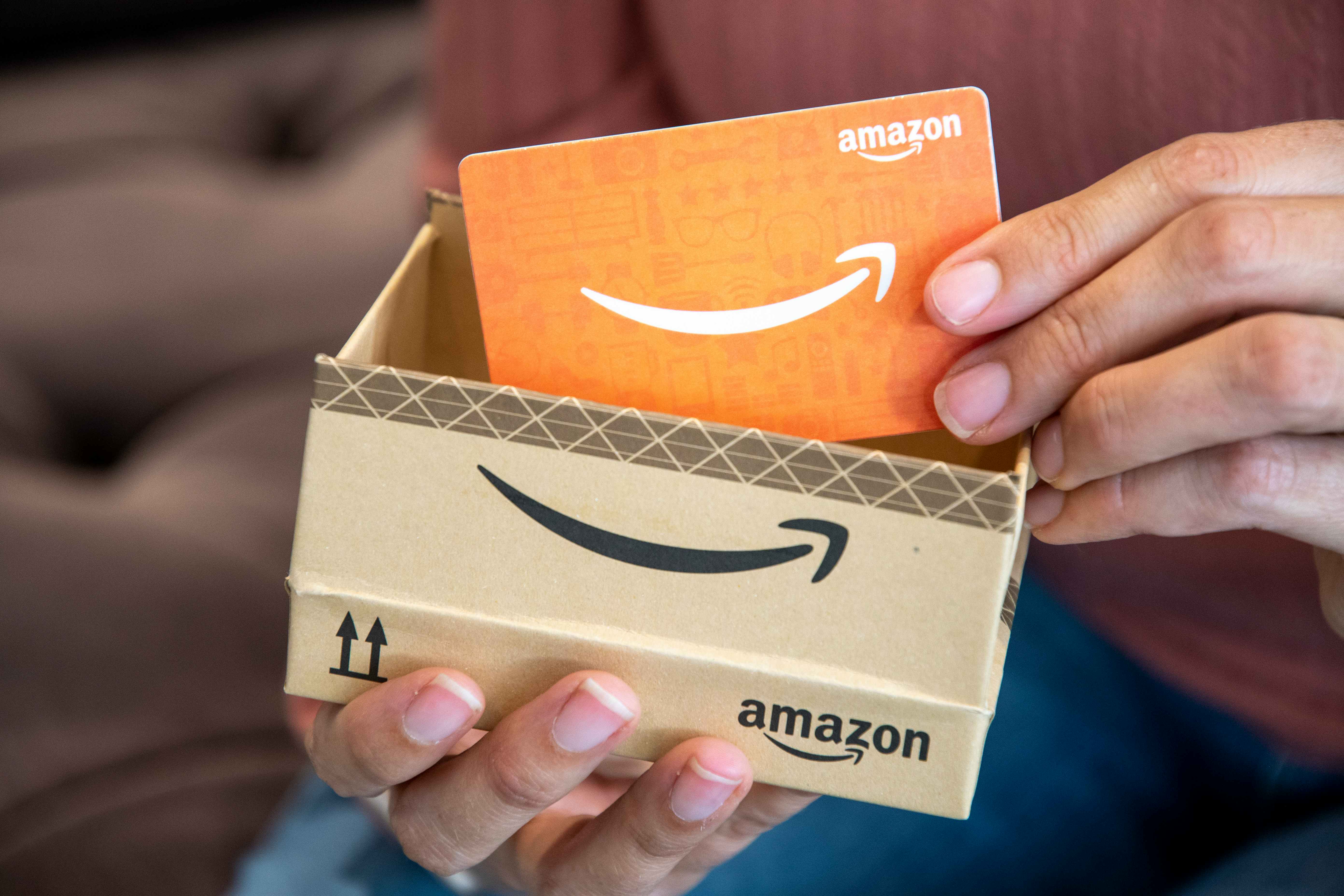 person removing amazon gift card from box