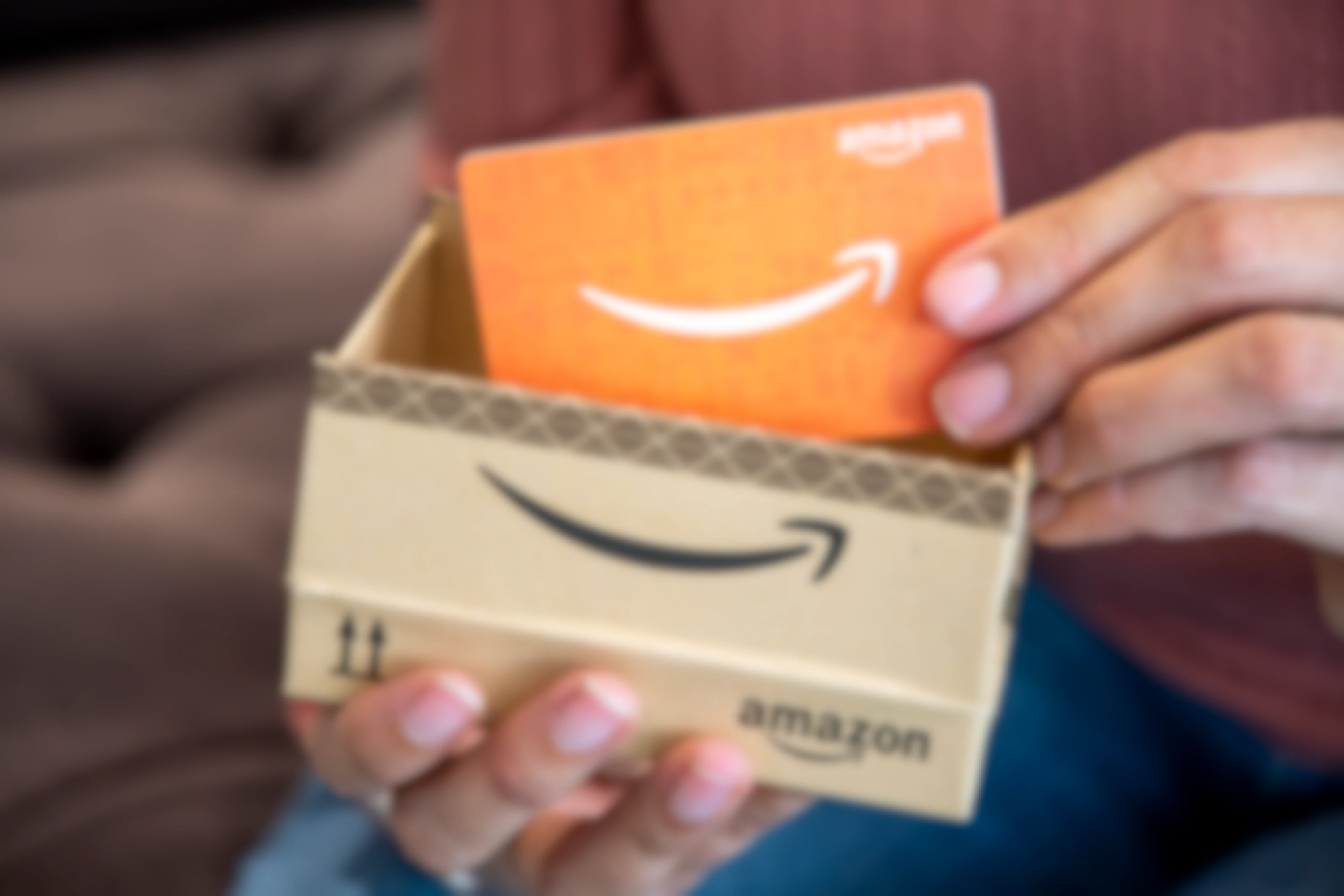 person removing amazon gift card from box