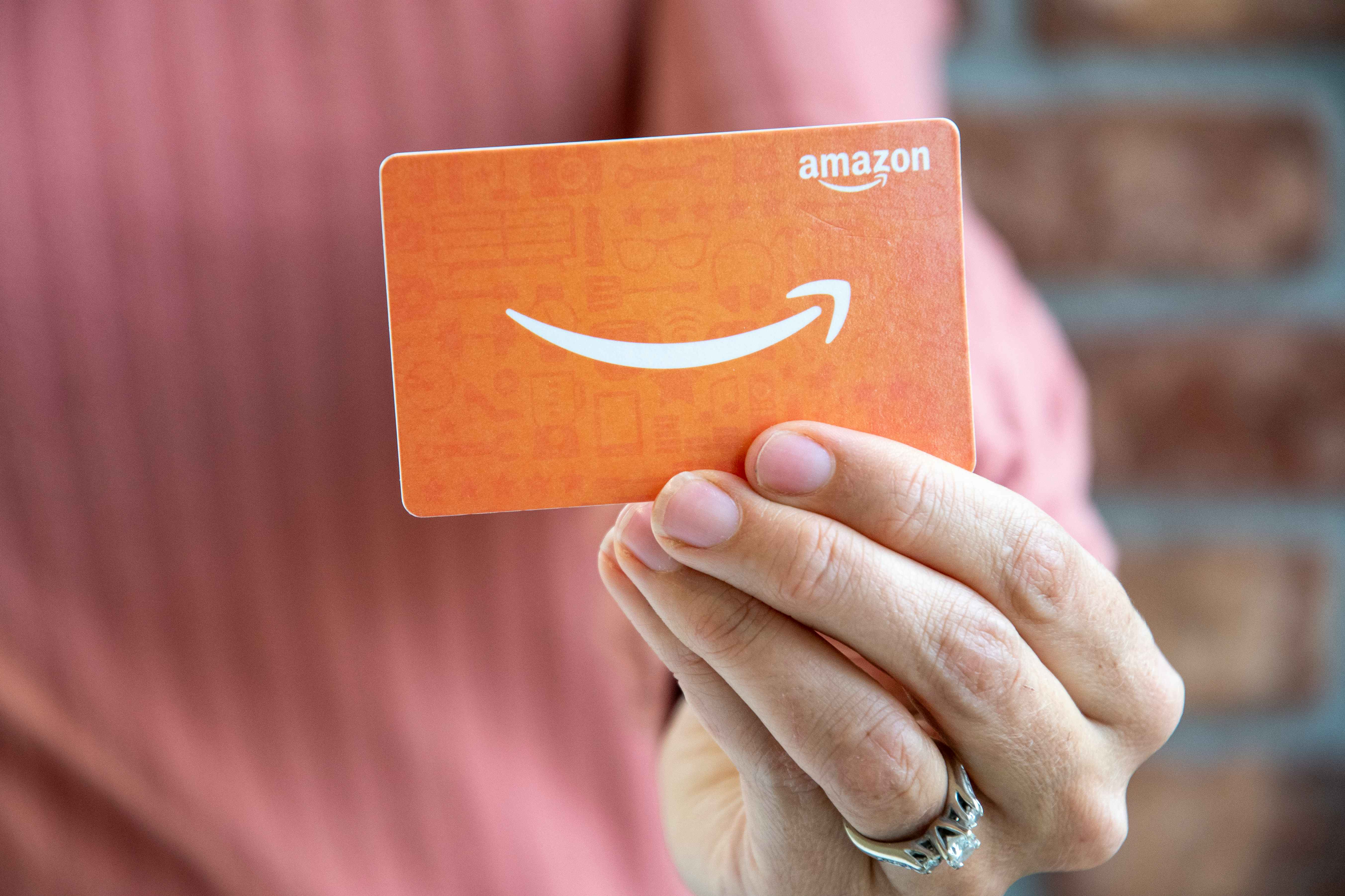 A person holding an Amazon gift card.