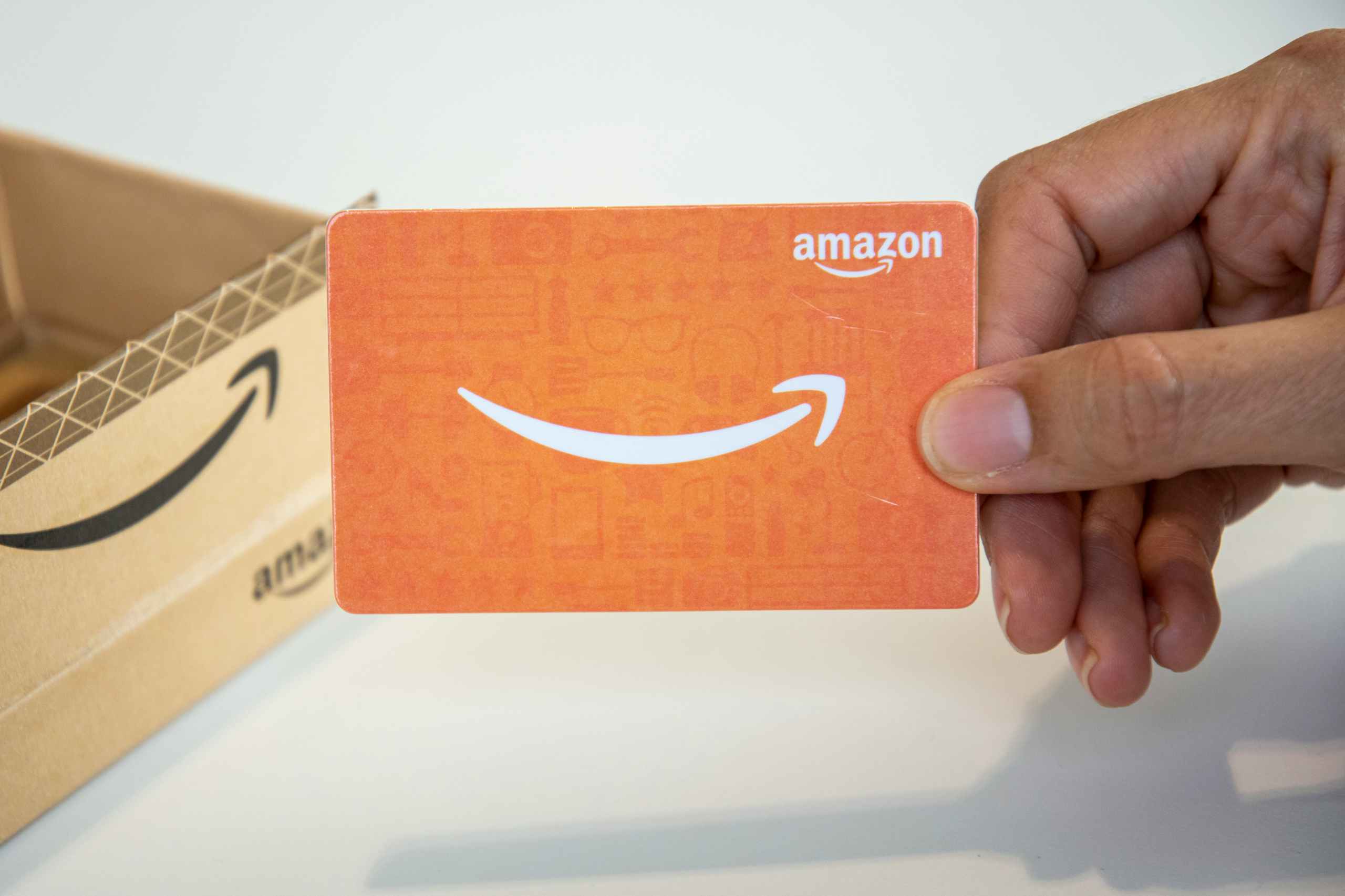 A person holding an Amazon gift card.