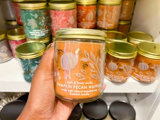 hand holding single wick fall candle