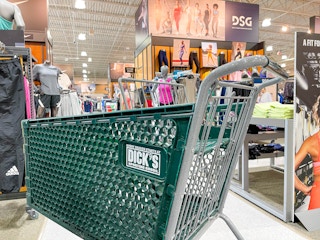 A Dick's Sporting Goods shopping cart in the middle of an aisle at Dick's.