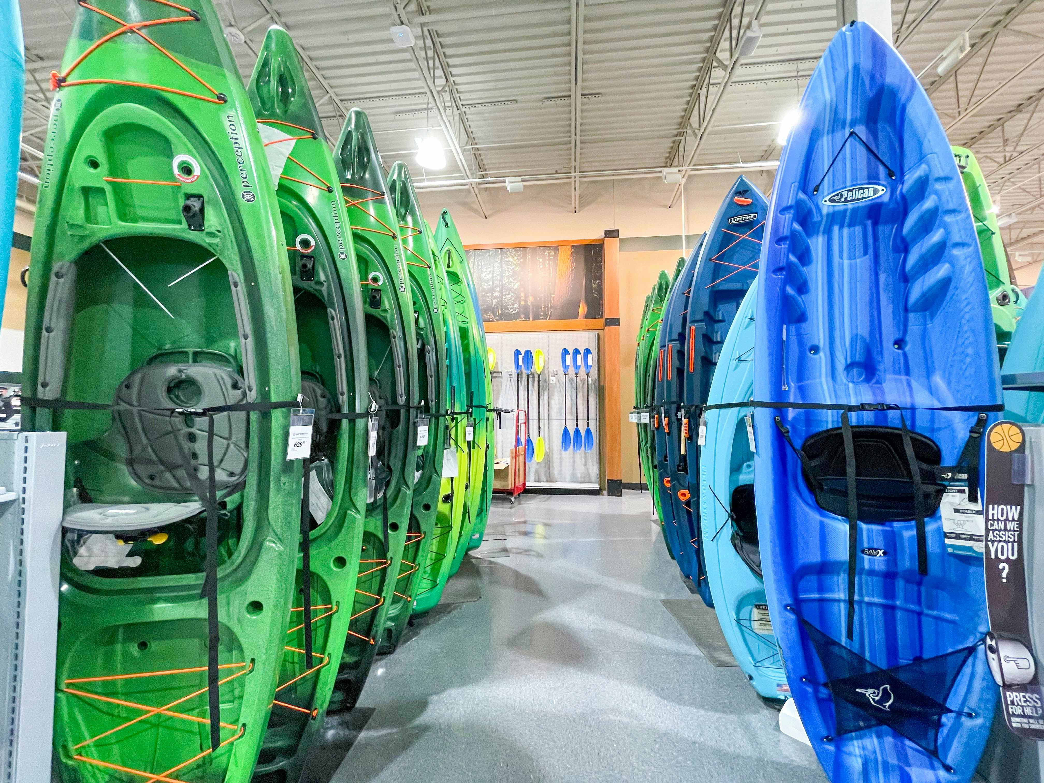Blue and green Kayaks in rows, for sale at Dicks Sporting Goods.