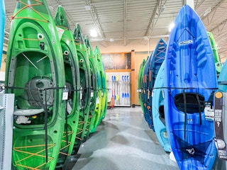 Blue and green Kayaks in rows, for sale at Dicks Sporting Goods.