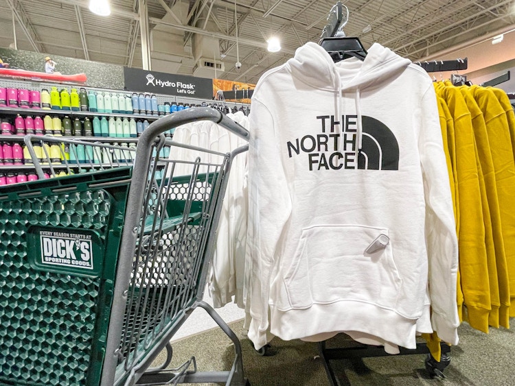 A The North face sweater next to a Dicks sporting Goods shopping cart