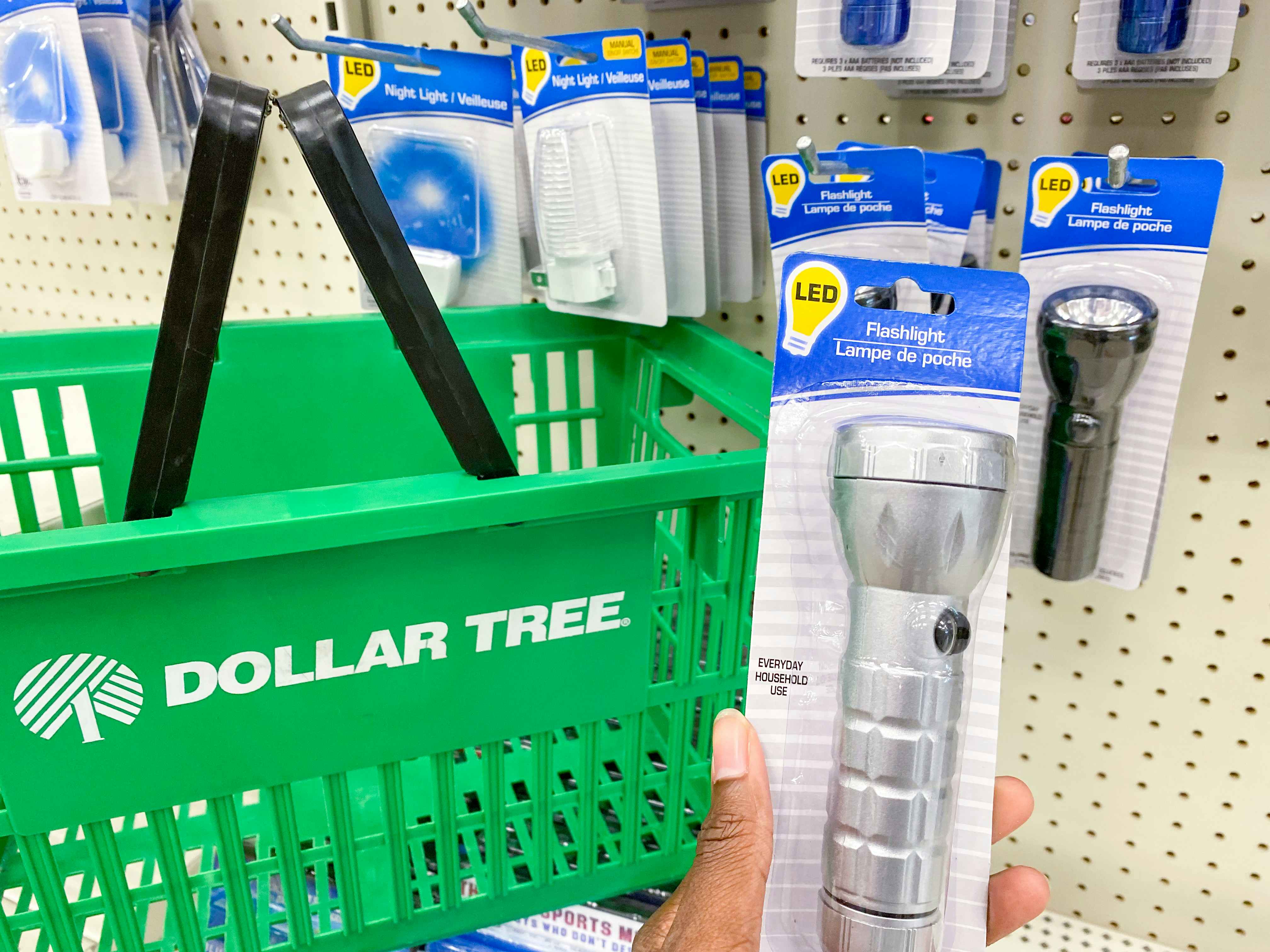 a flashlight held in hand next to a dollar tree basket in dollar tree