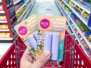 hand holding 2 packs of eos lip balm at target