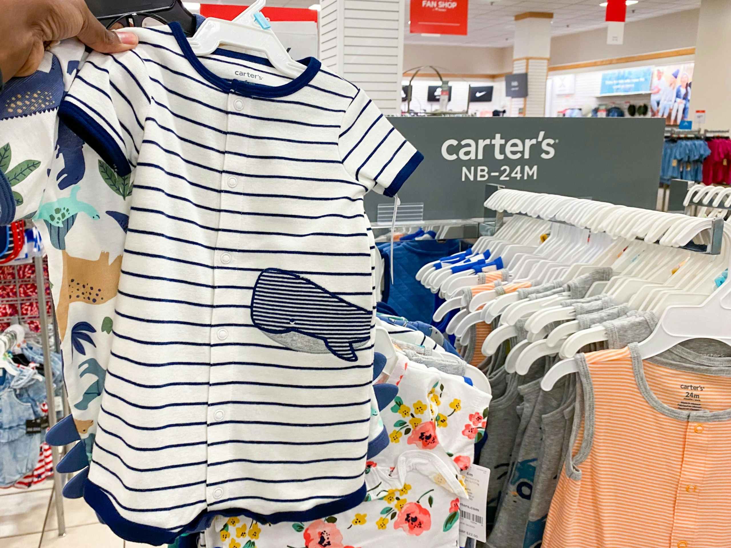 hand holding carter's baby romper