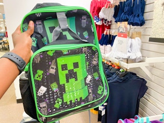 someone grabbing a backpack in the kids clothing section at jcpenney