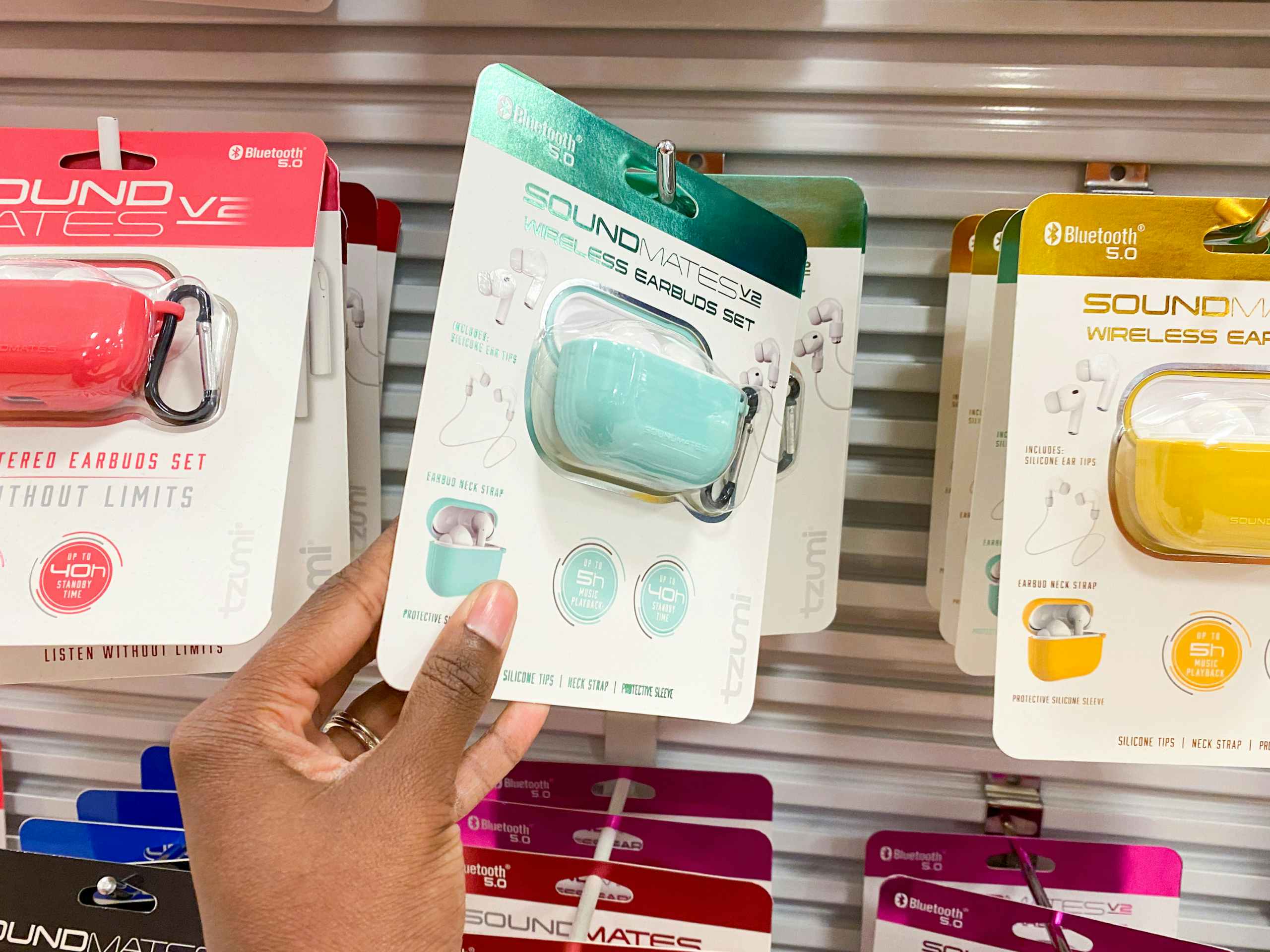 someone picking up a pair of earbuds in the earbud section at jc penny