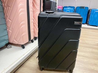 luggage on the floor next to a shelf of other luggages