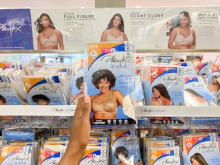 a pack of playtex bras held in hand, In front of a display of playtex bras on racks in kohl's