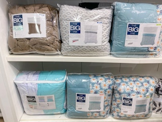 the big one comforters displayed on two shelfs in kohls