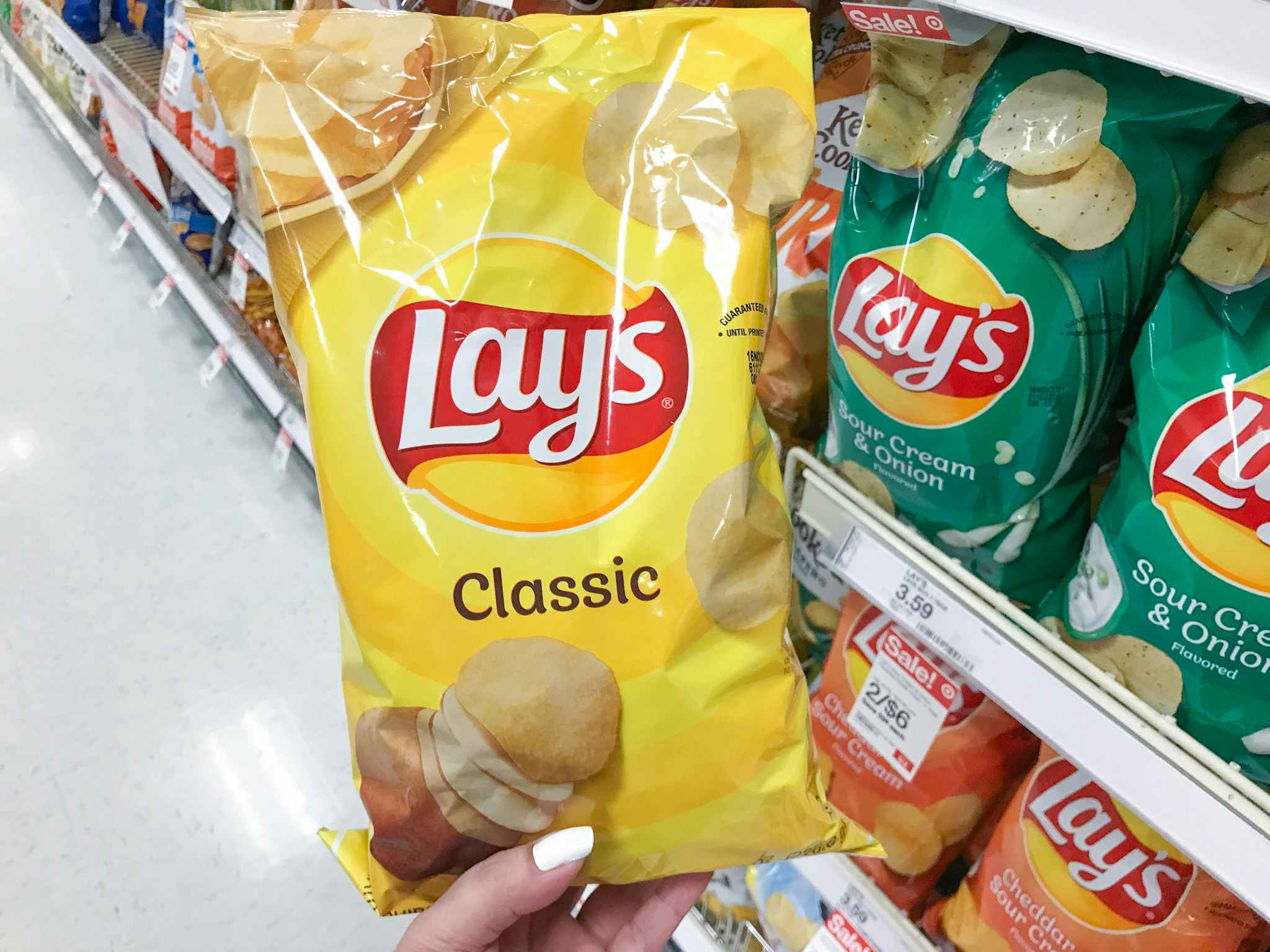 hand holding a bag of lay's chips at target