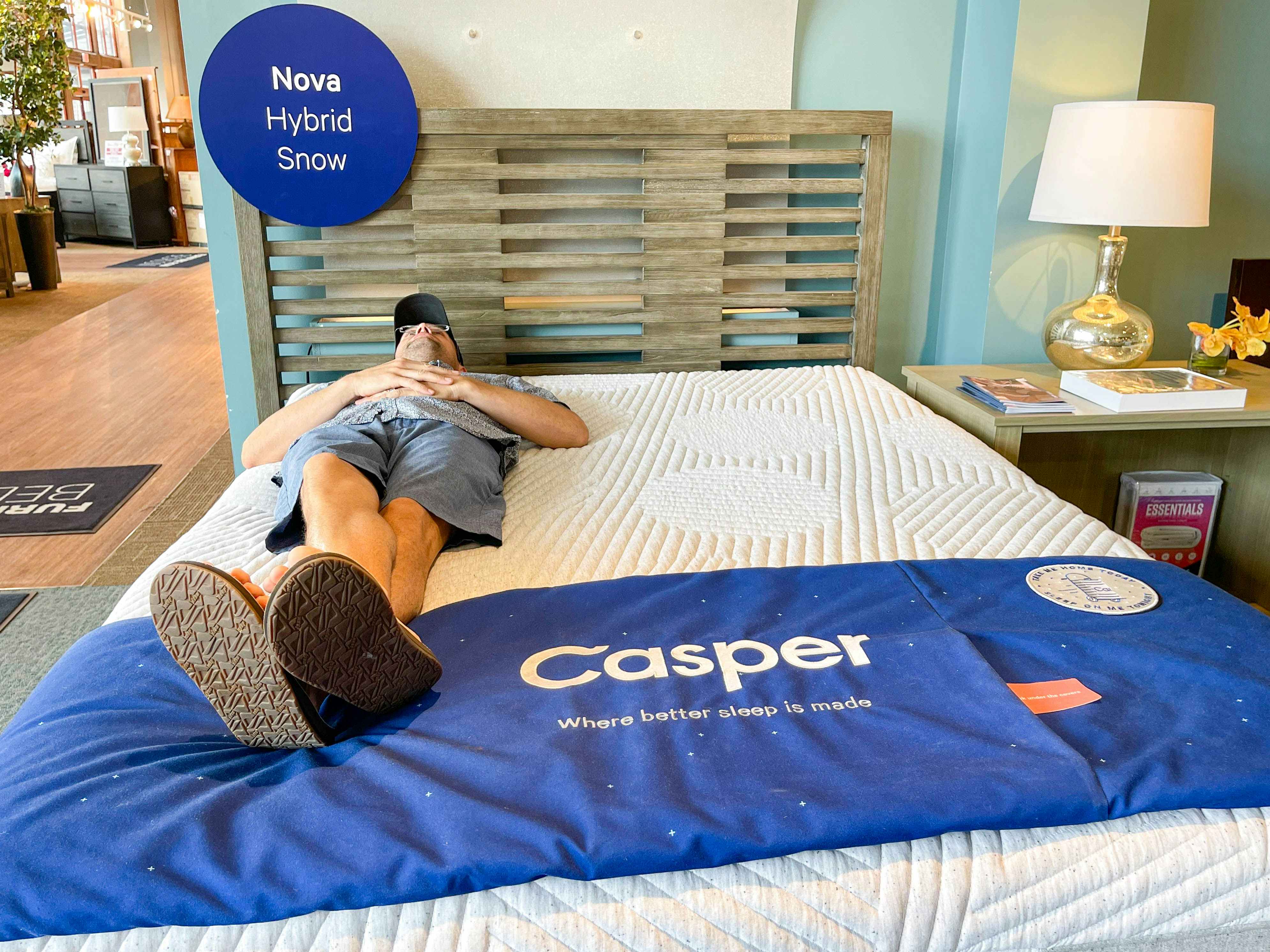 man lying on casper nova hybrid mattress in store