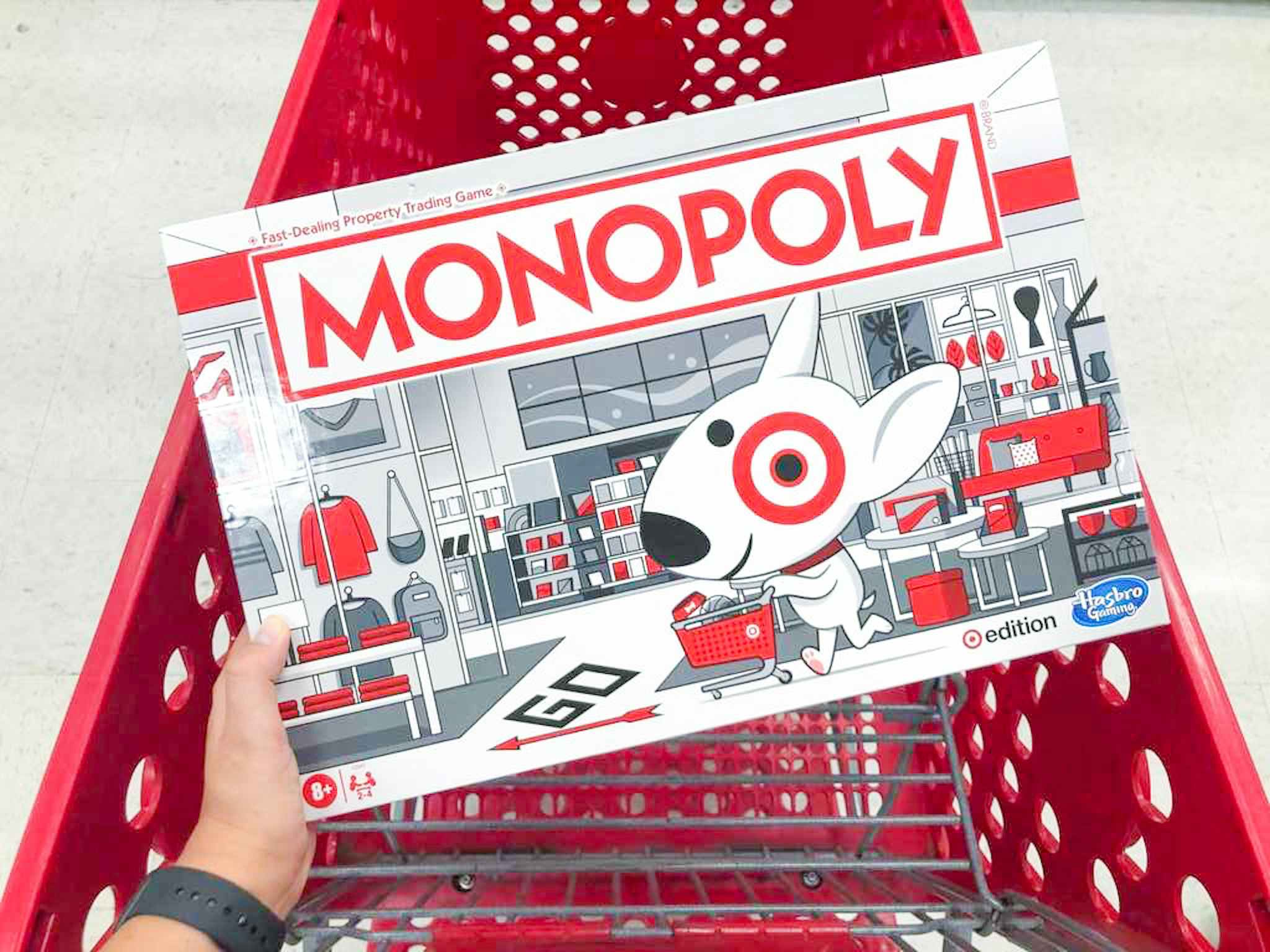 hand holding monopoly target edition game over a target cart