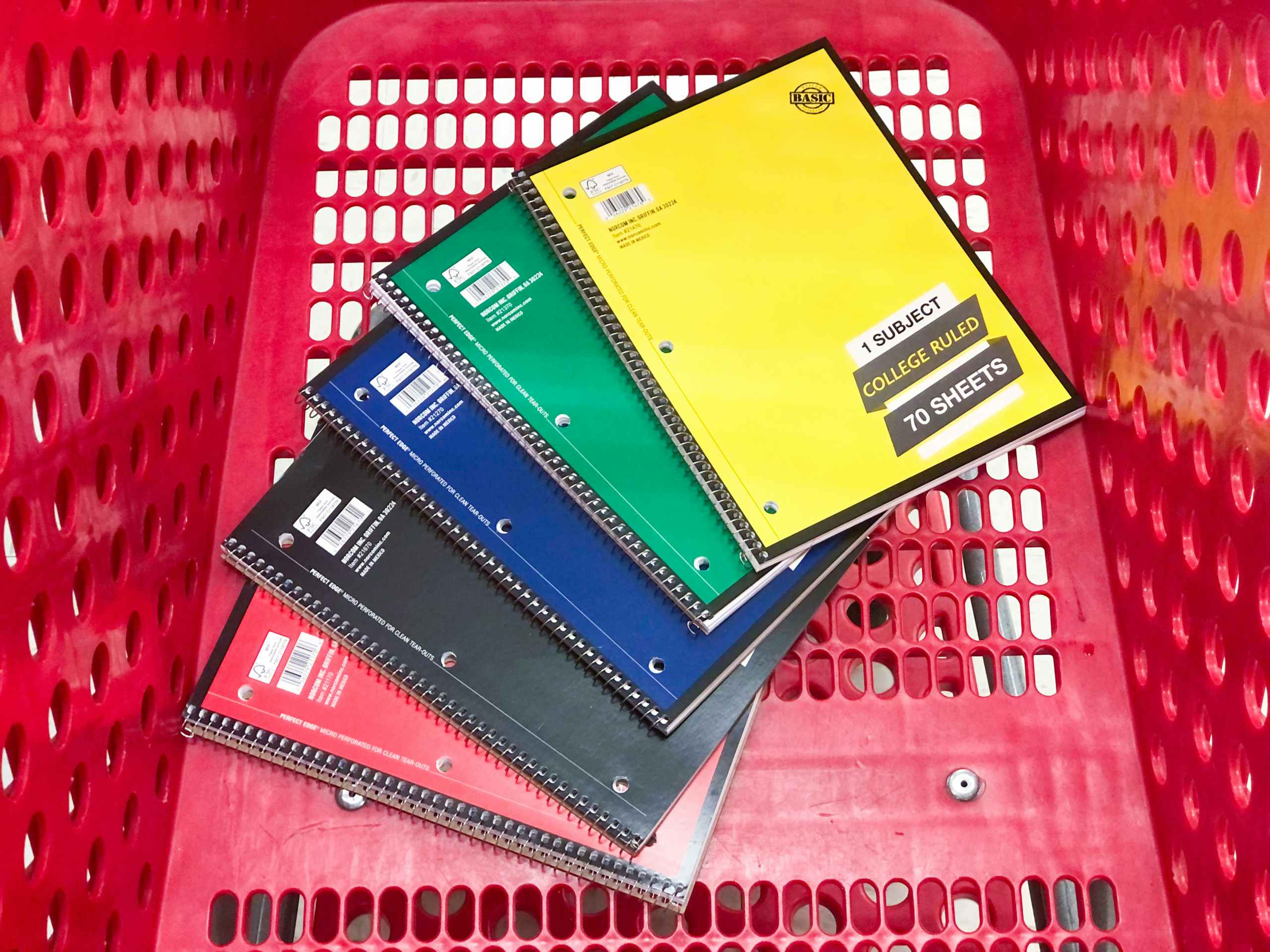 five notebooks stacked in shopping cart