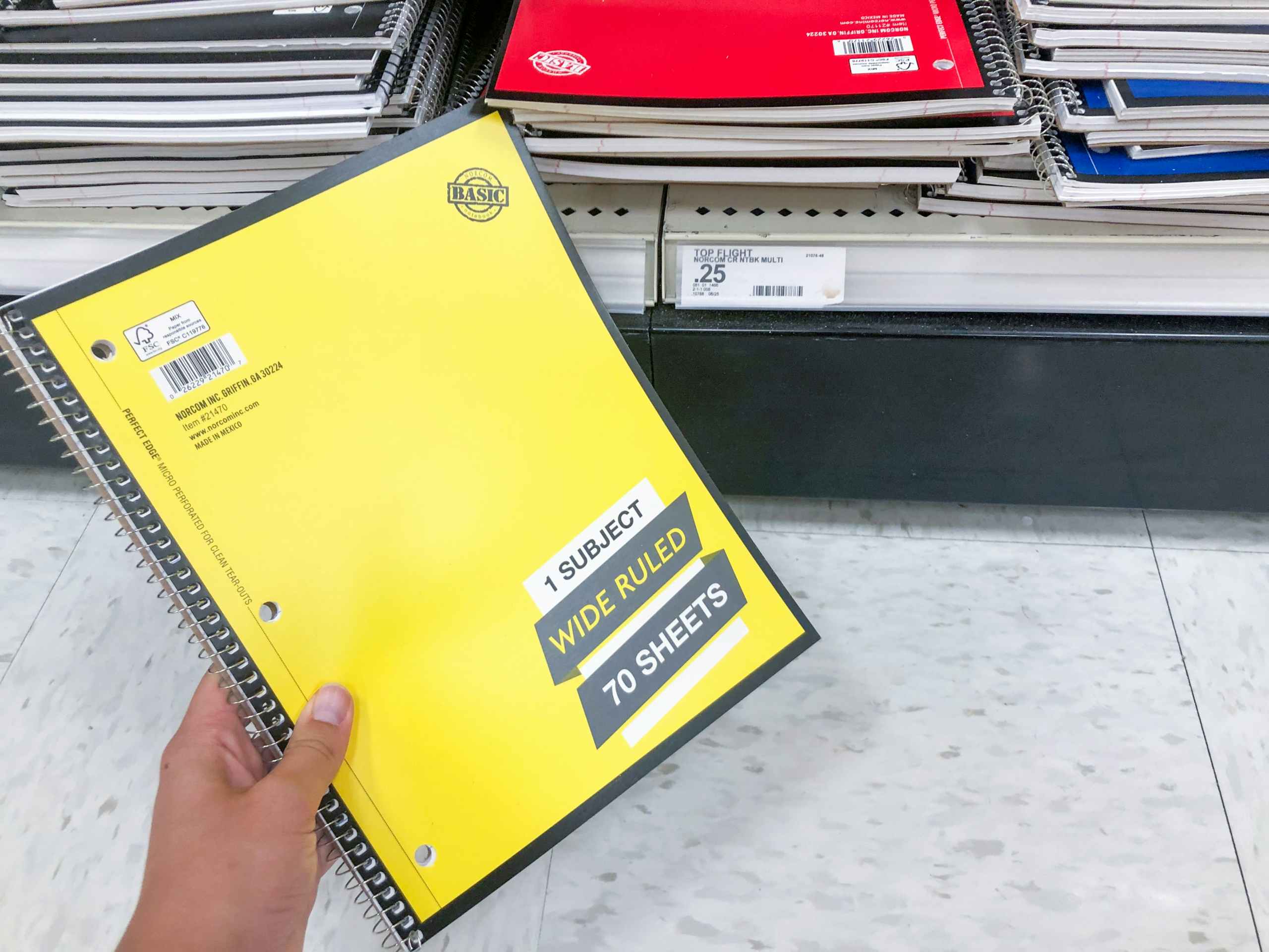 hand holding notebook in front of store shelf