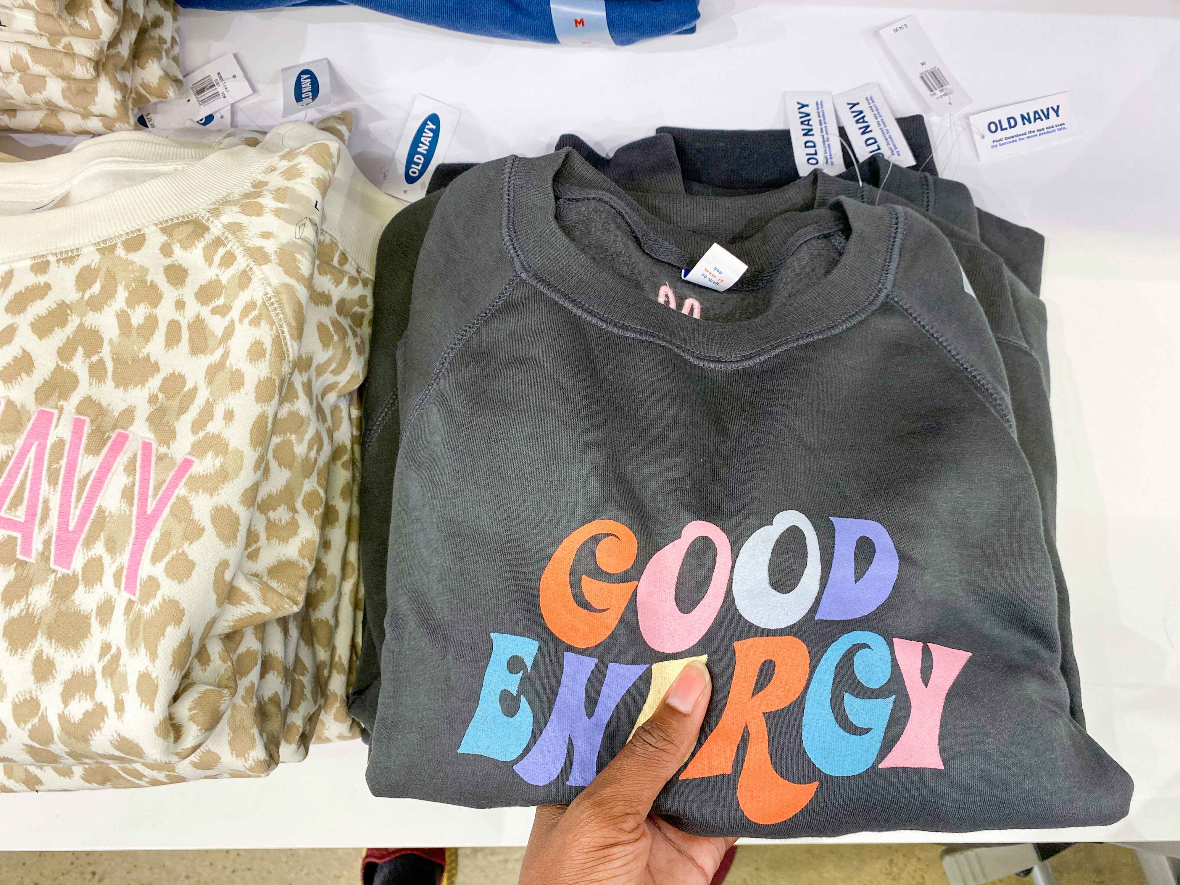 a womens old navy sweater held in hand on a table in old navy