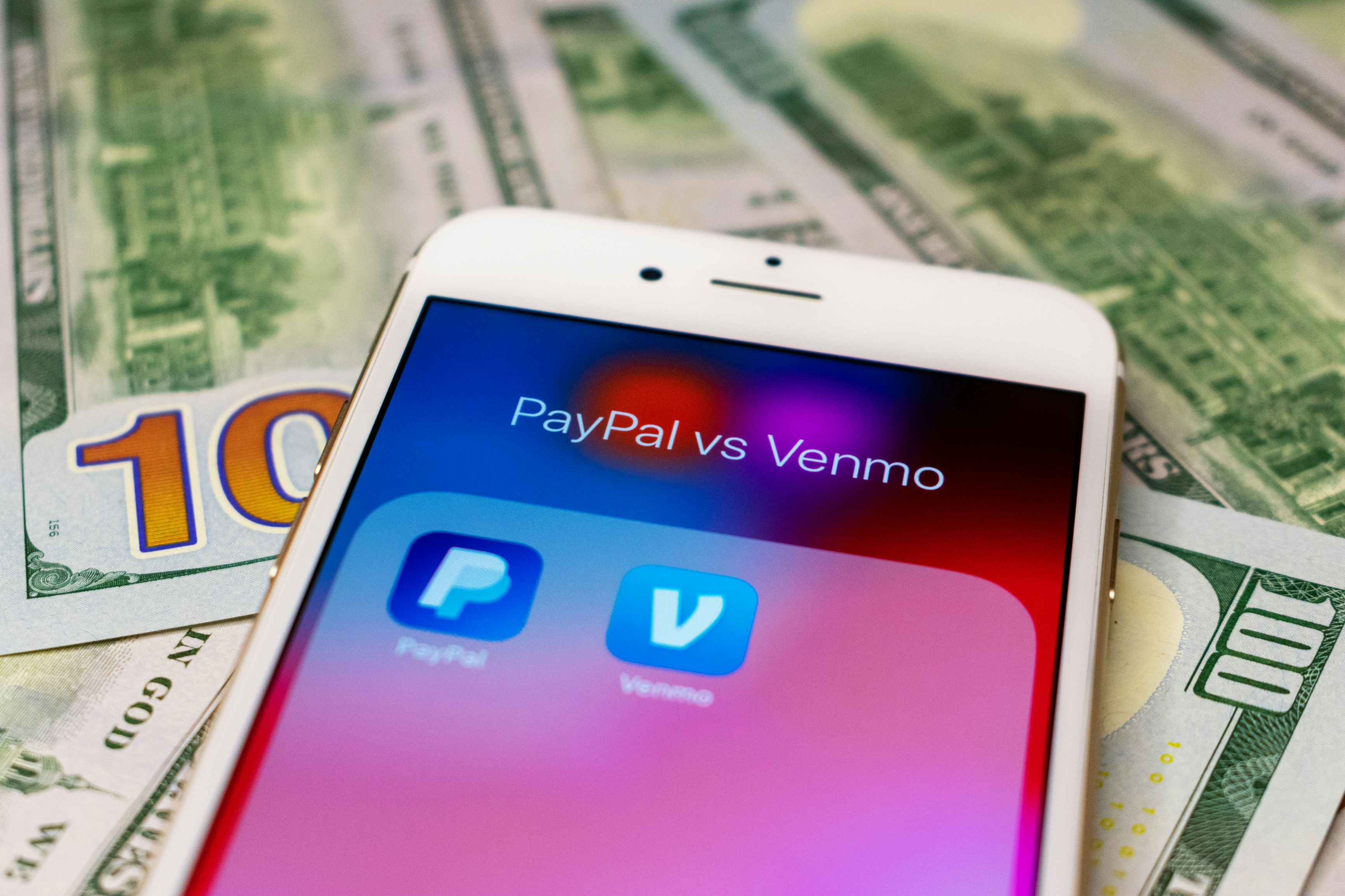 phone on top of money with a screen showing the venmo and paypal app