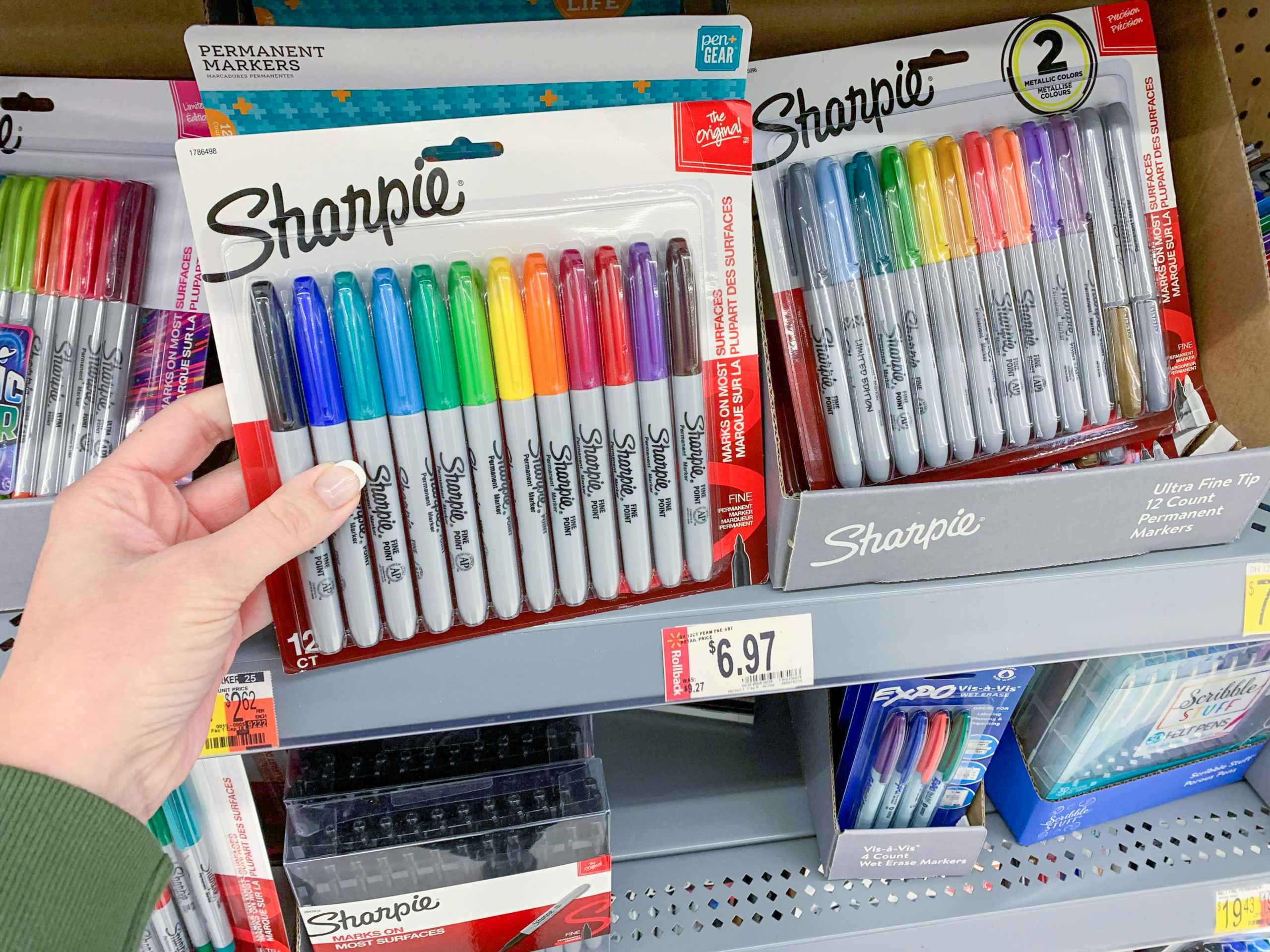 hand holding pack of sharpies in front ot Walmart store shelf