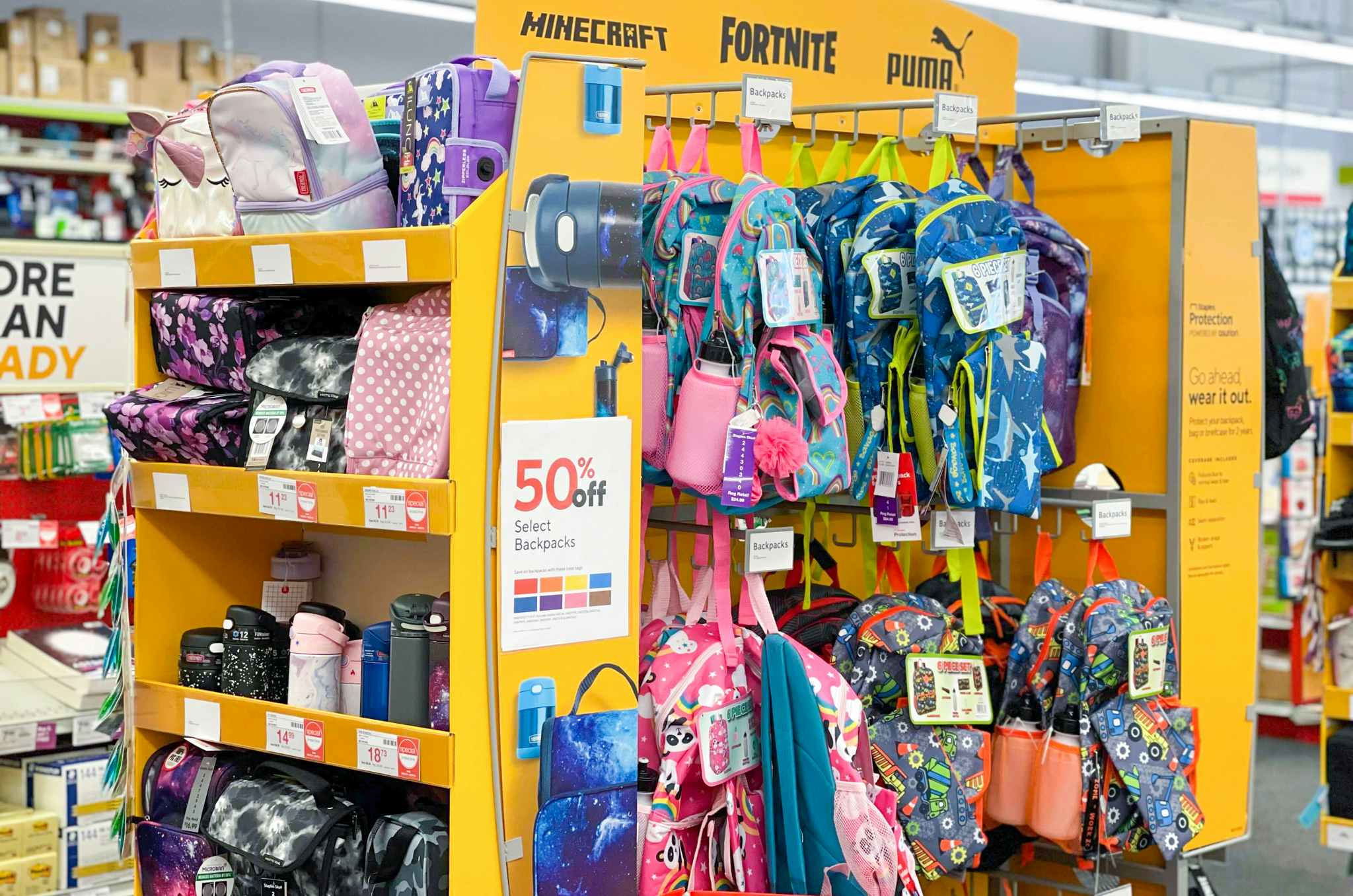 A backpack display inside Staples with a sign that reads, "50% off select backpacks