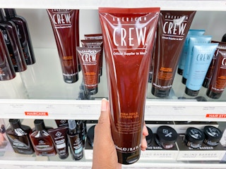american crew styling gel held in hand in front of other similar products
