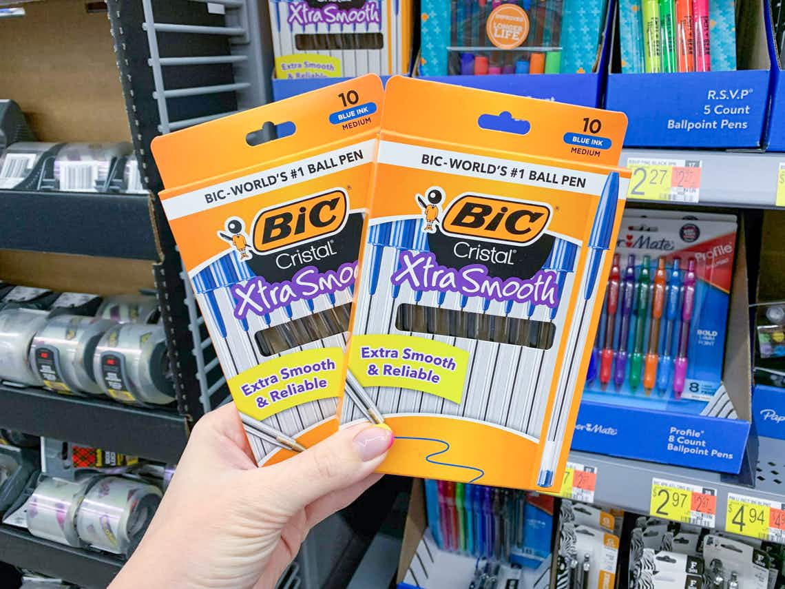 two boxes of bic cristal xtra smooth pens held up in front of other pens