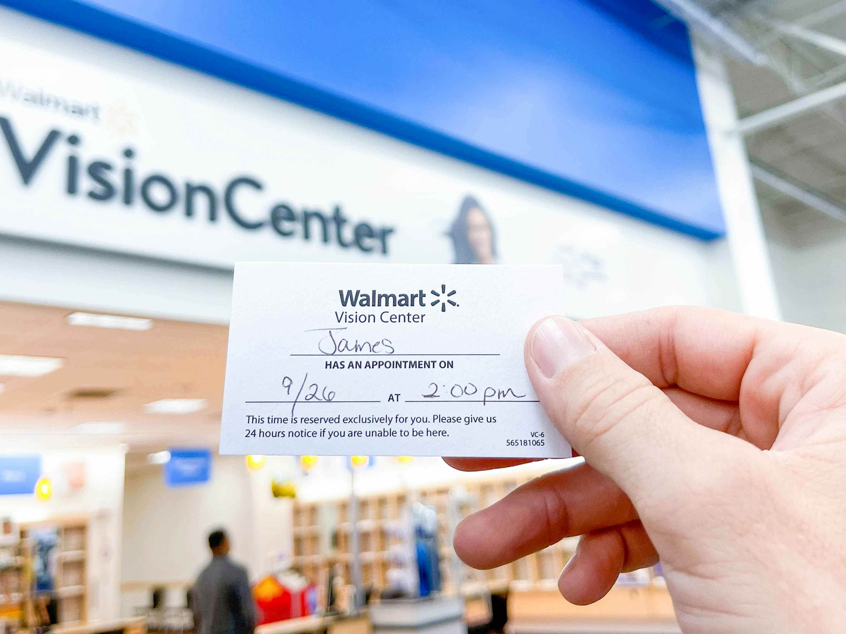 holding up a walmart vision eye center appointment card in store 