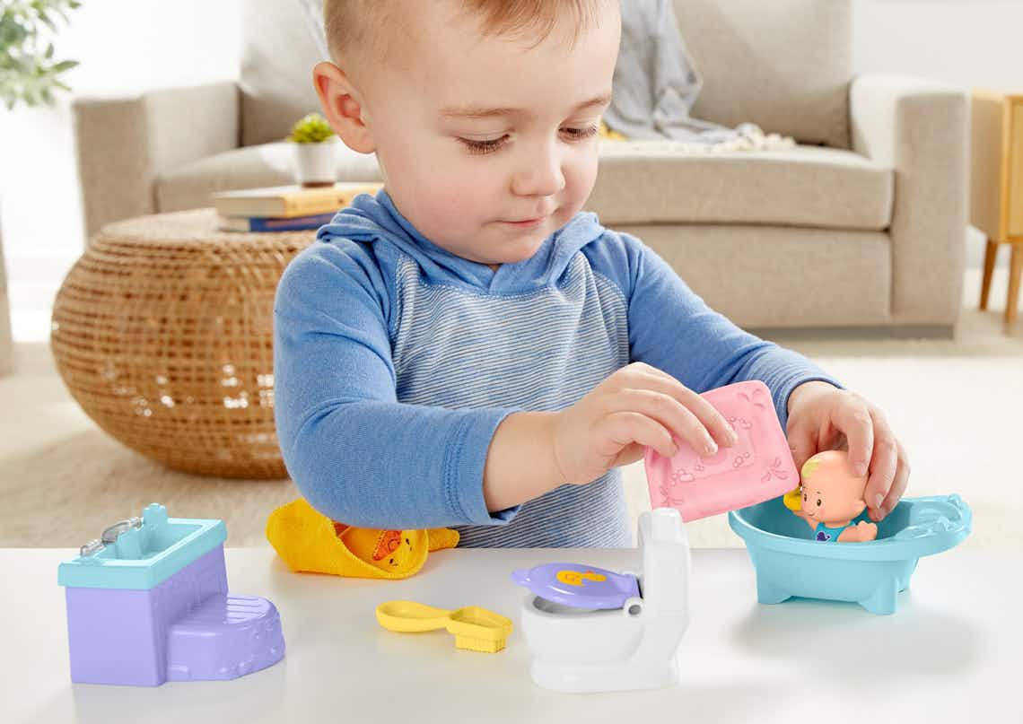 stock photo of toddler playing with fisher price little people wash and play baby toy