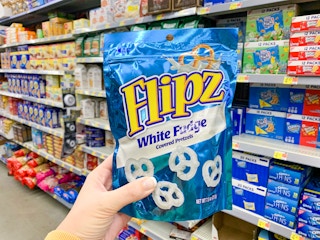 flipz fudge covered pretzels held up in front of shelves