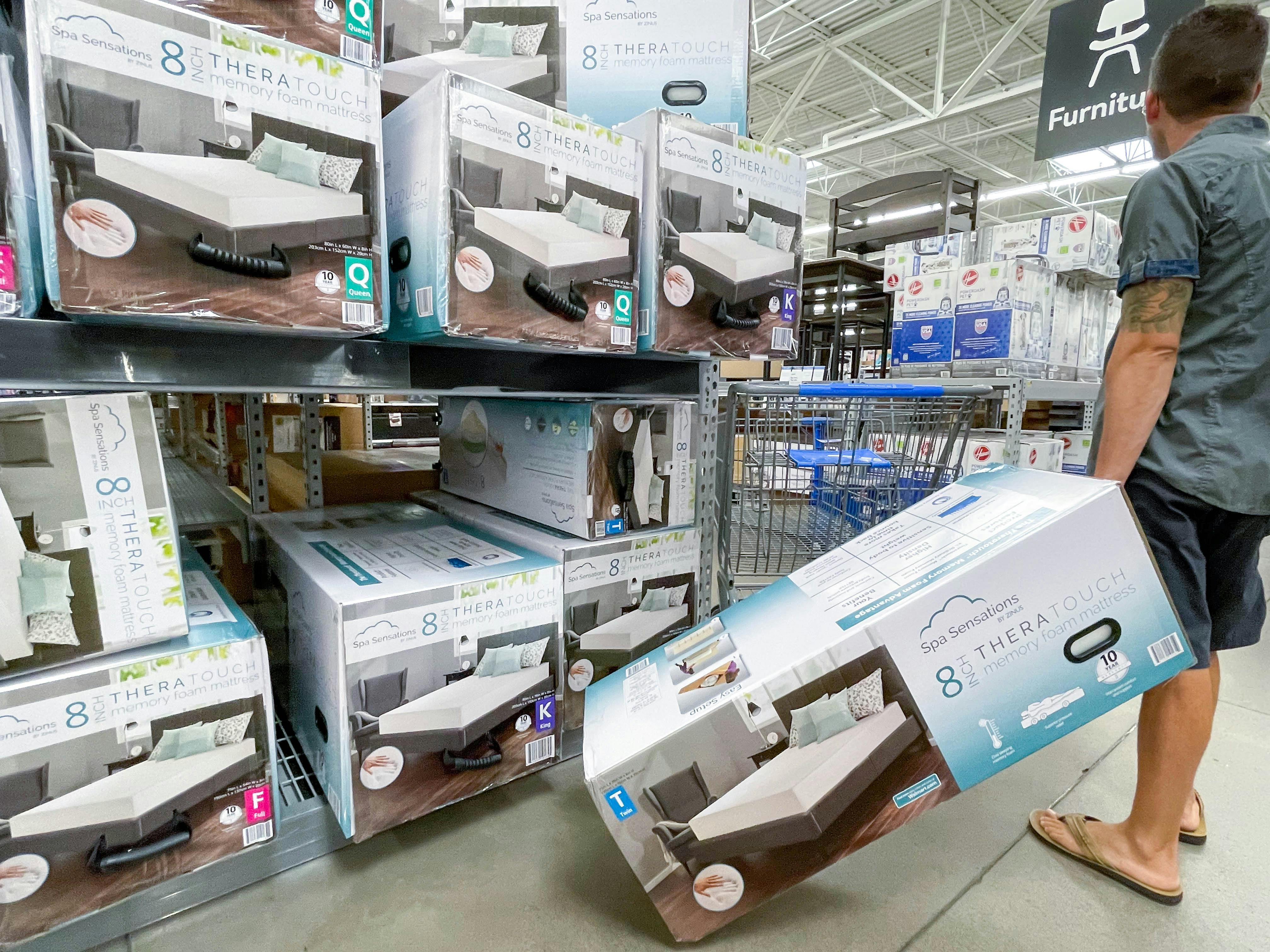 man holding box for memory foam bed in walmart aisle