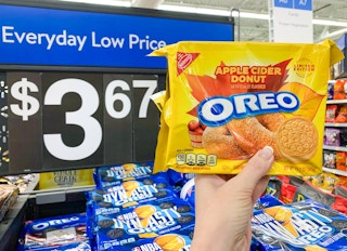 oreo apple cider donut cookies held up in front of price sign