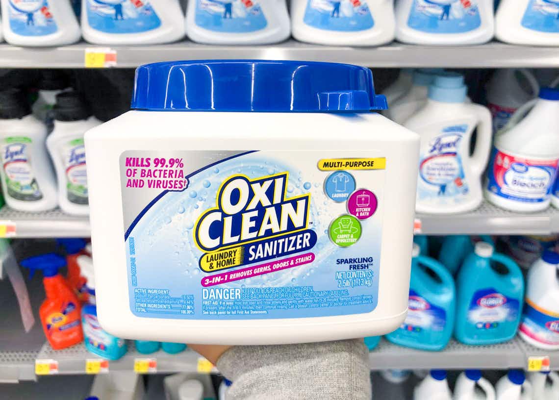 canister of oxi-clean laundry and home sanitizer held in front of shelves