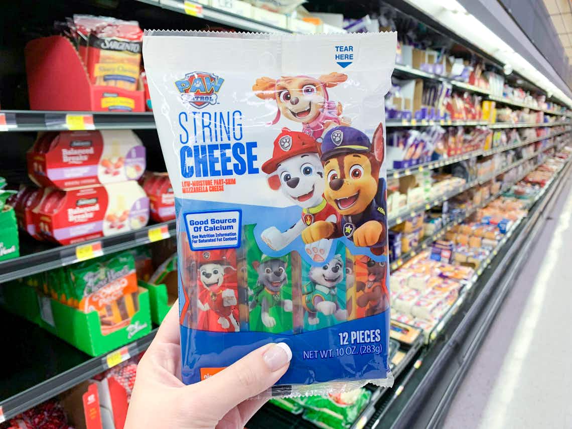 paw patrol string cheese held up in front of cheese aisle