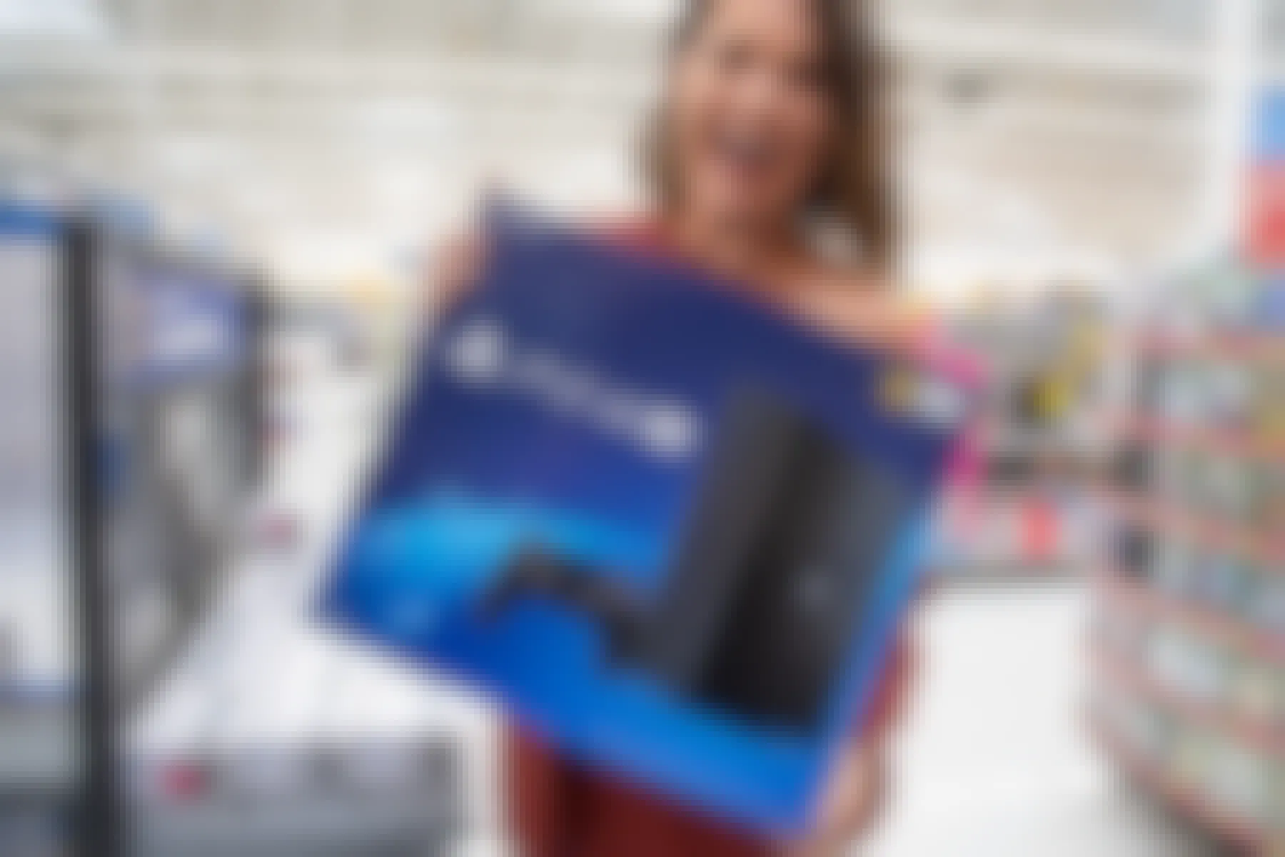 A woman holding a playstation 4 inside Walmart