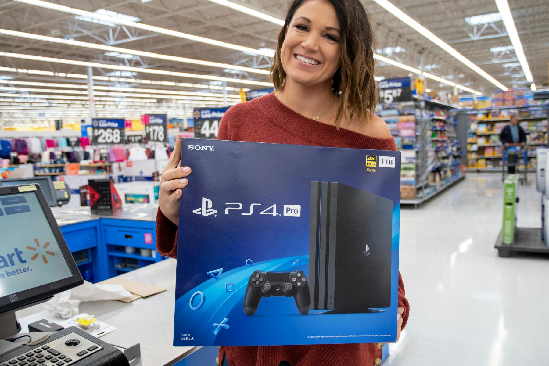 A woman holding a playstation 4 inside Walmart