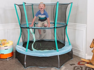 stock photo of skywalker trampoline staged in room with little boy jumping
