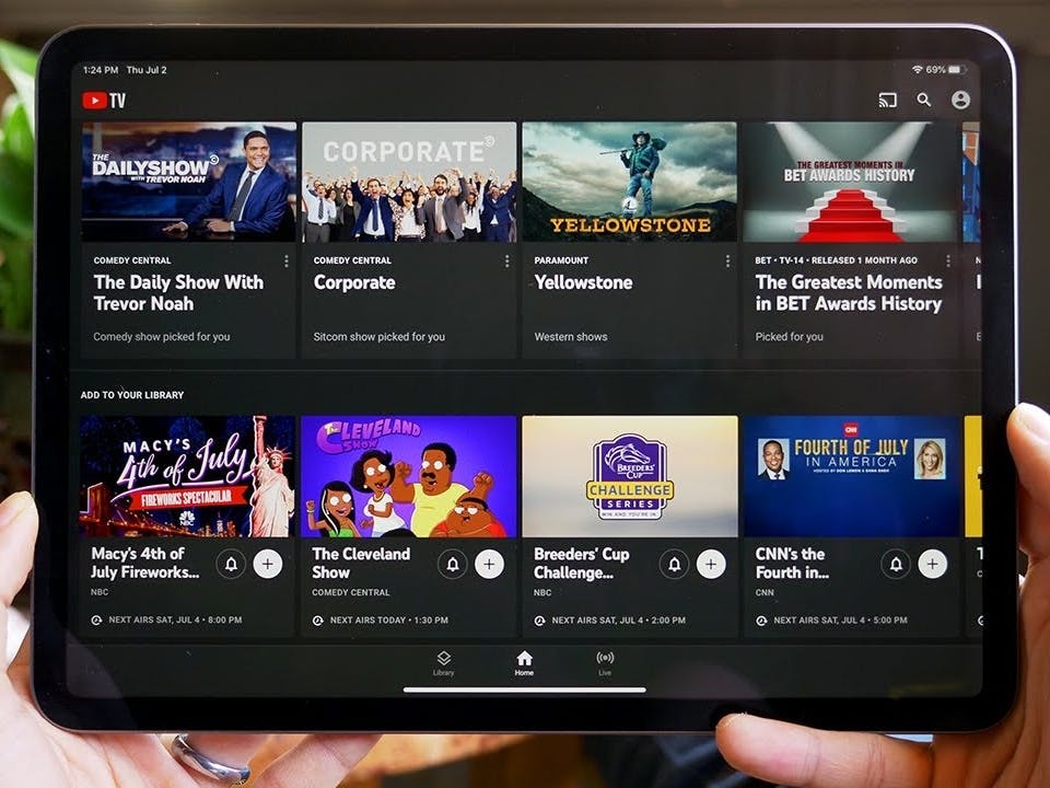 YouTube TV displayed on an iPad that is being held up.