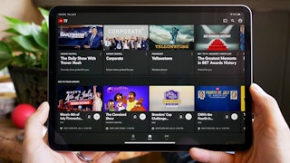 YouTube TV displayed on an iPad that is being held up.