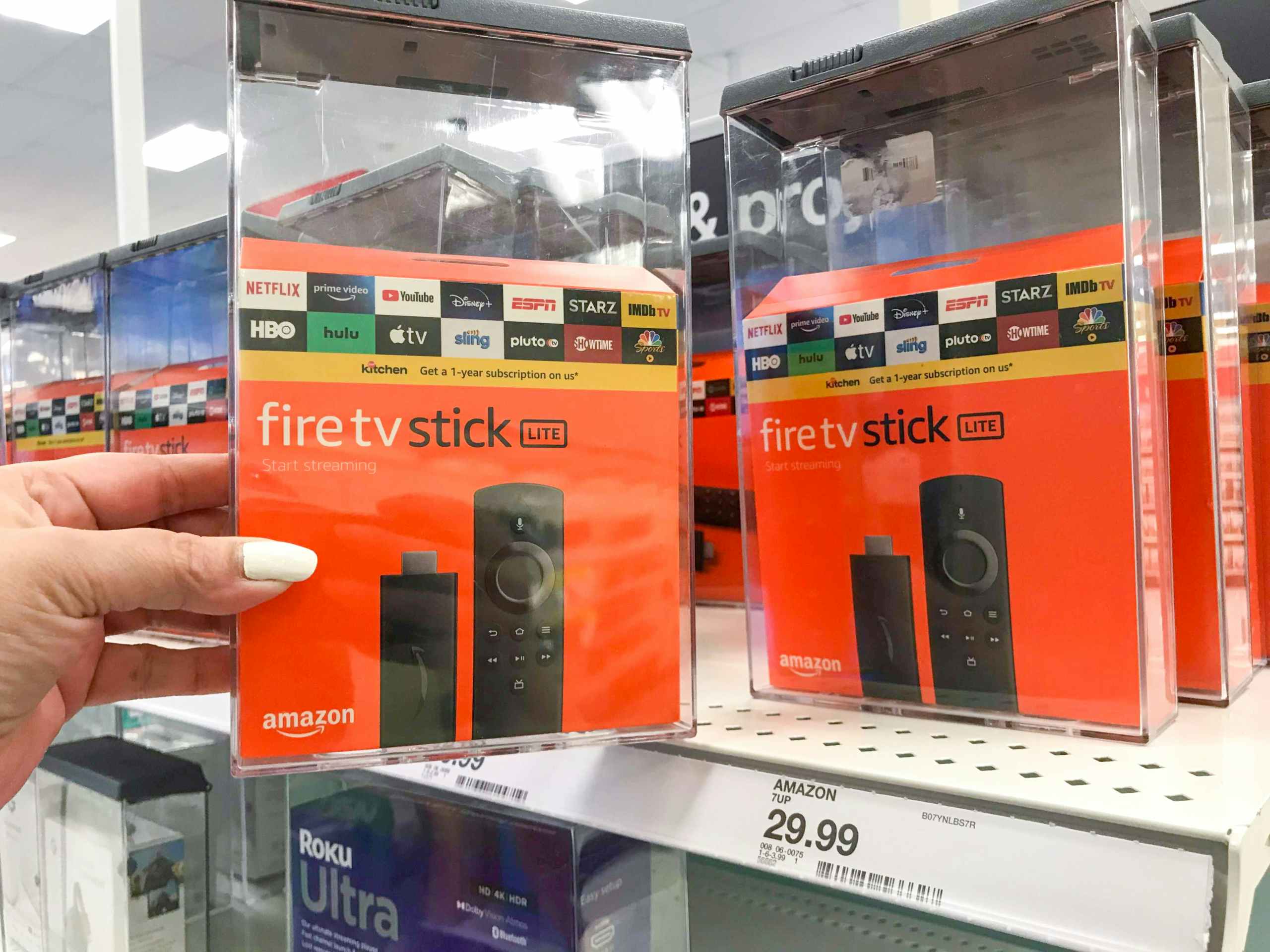 hand holding Amazon fire stick box in front of Target store shelf