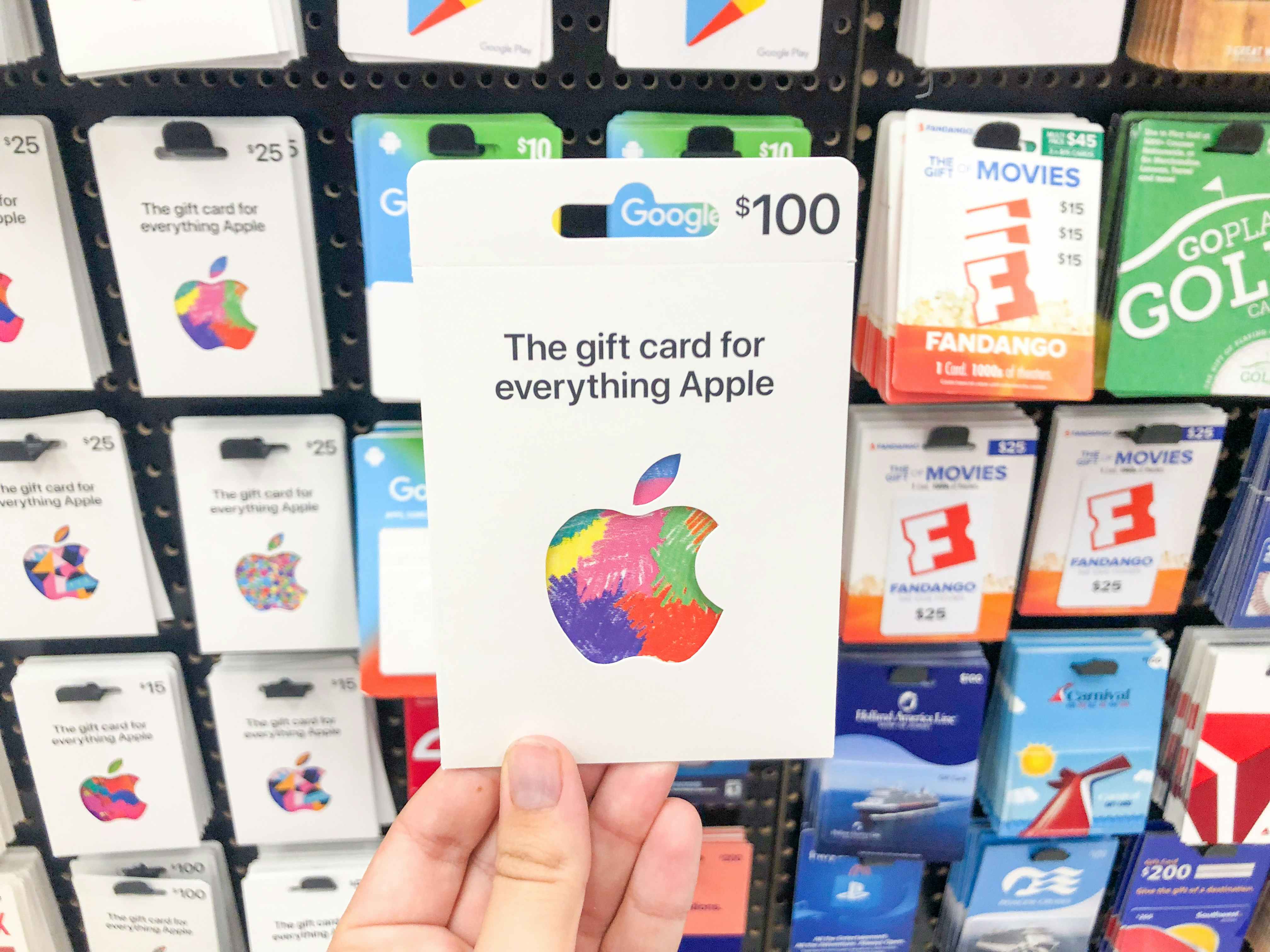 hand holding Apple gift card in front of gift card display at Target