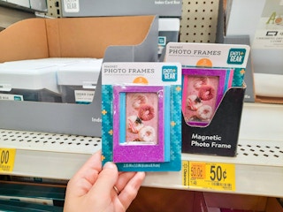hand holding photo frames at Walmart in front of store shelf