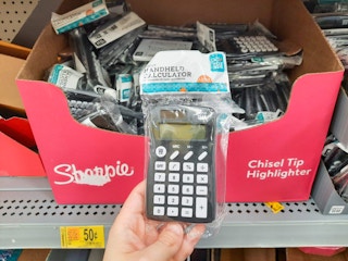 hand holding calculator at Walmart in front of store shelf