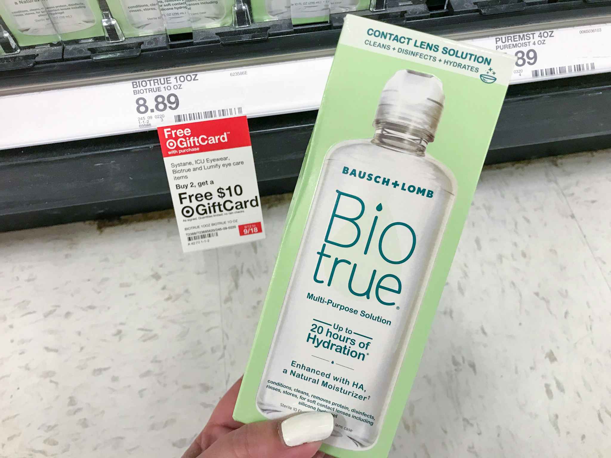 hand holding biotrue contact solution in front of target gift card tag