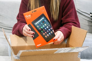 A person taking an Amazon fire 7 tablet out of a box.
