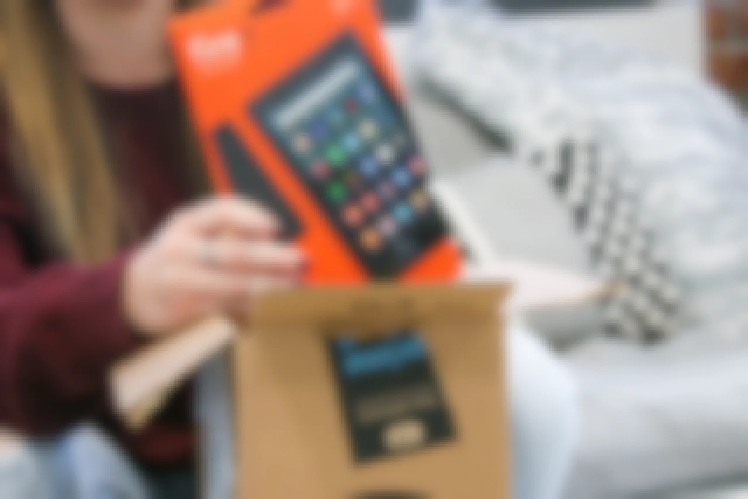 A person taking an Amazon Fire 7 tablet out of an Amazon box.
