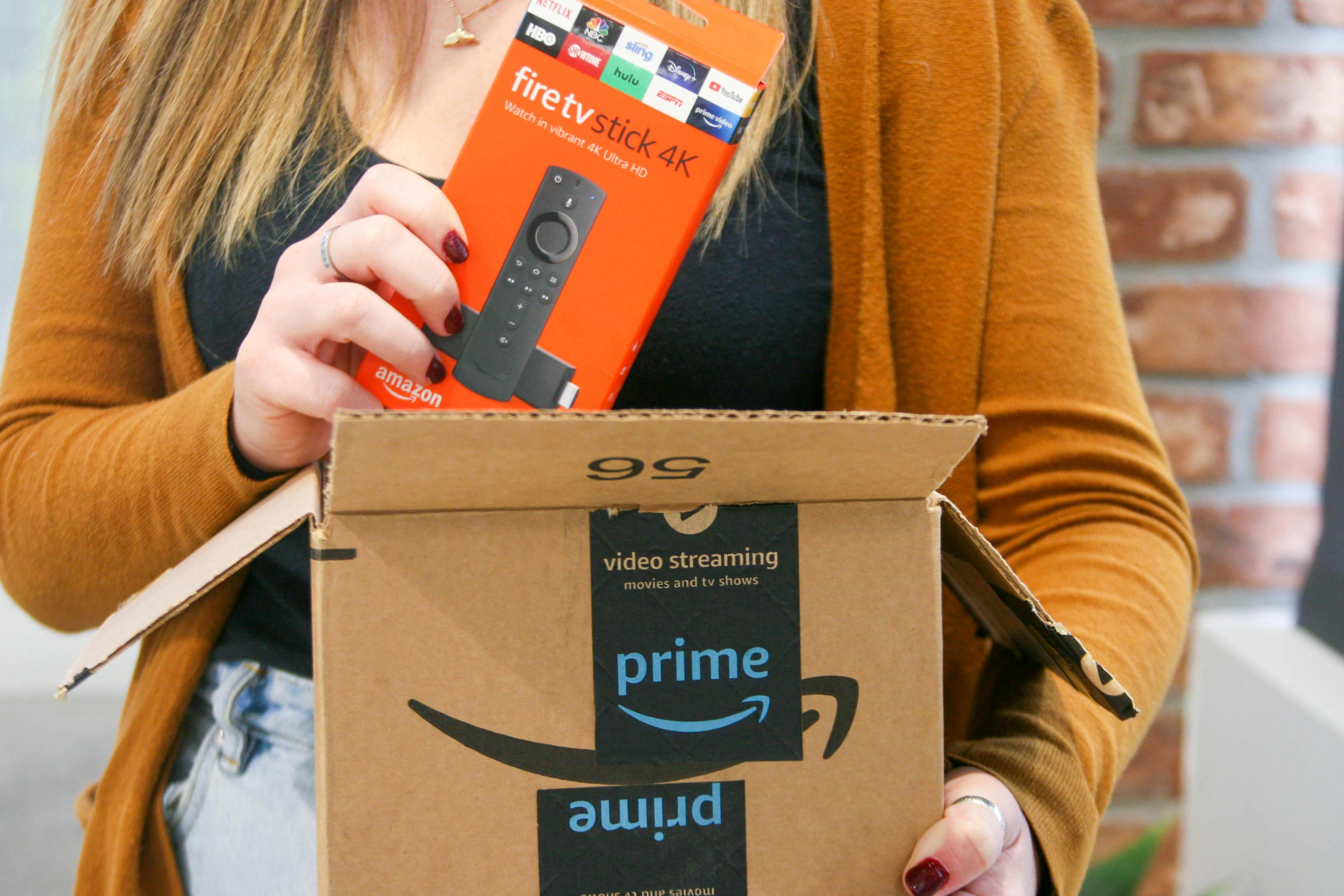 A person taking a Fire TV Stick 4k out of an Amazon box.