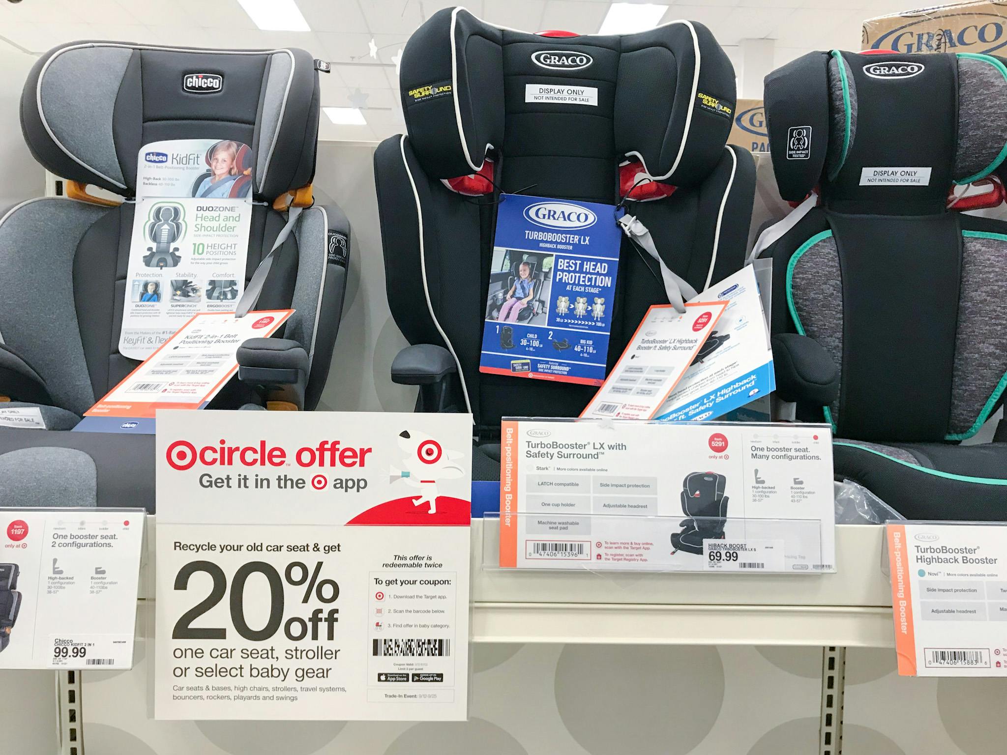 Car seats on the shelf at Target with a sign advertising 20% off car seat trade-in offer.